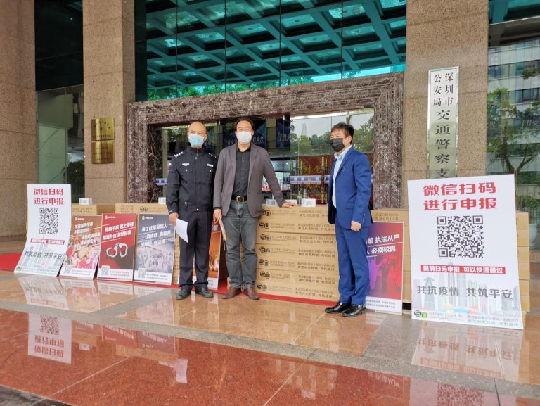 Store Display Group Chairman Chen Mao presenting pandemic prevention materials to Shenzhen Traffic Police Bureau representatives during the donation event.